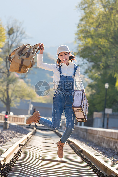 美女青年人徒步旅行青年女人在铁轨上跳跃图片