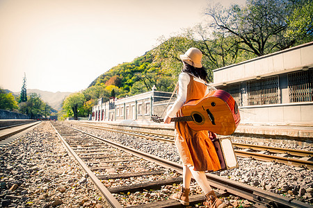 环境保护温馨乐器青年女人在铁轨上行走图片