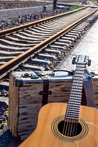 环境保护交通怀旧铁轨旁边的吉他和旅行箱图片