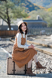 旅行箱20多岁青年女人坐在铁轨上图片