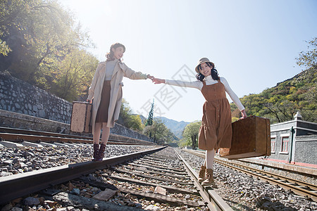 步行东方人铁路青年闺蜜手牵手走在铁轨上图片