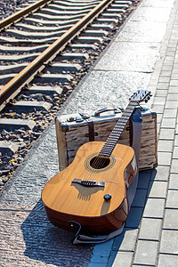 道路传统文化铁轨旁边的吉他和旅行箱图片
