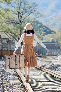 旅行郊游青年女人在铁轨上行走图片