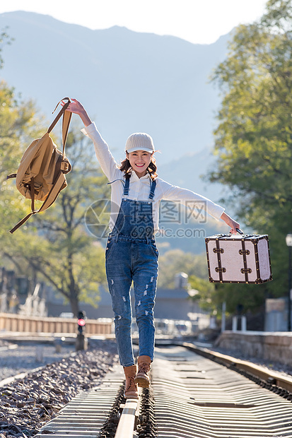 青年女人徒步走在铁轨上图片