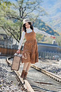 魅力青年女人在铁轨上行走图片