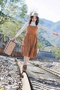 青年女人在铁轨上行走图片