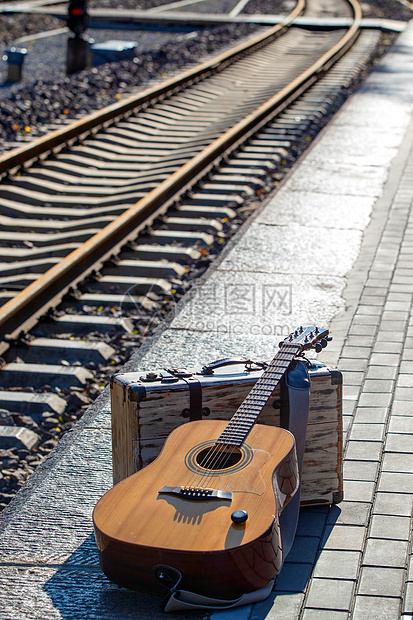 铁轨旁边的吉他和旅行箱图片