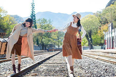 自然姐妹休闲装青年闺蜜手牵手走在铁轨上图片素材
