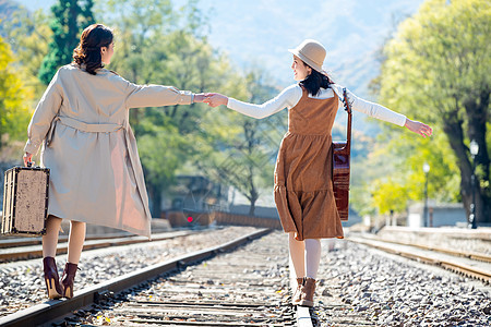 青年女人旅途旅行者青年闺蜜手牵手走在铁轨上图片