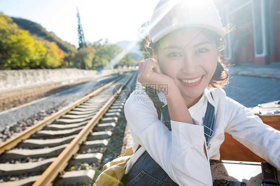 休闲装清新图片视觉效果青年女人坐在火车站站台上图片