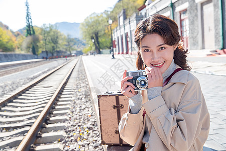 旅行的青年女人拿着照相机图片