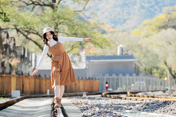 环境保护交通复古青年女人在铁轨上行走图片