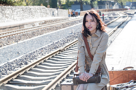 人彩色图片优雅青年女人坐在火车站站台上图片
