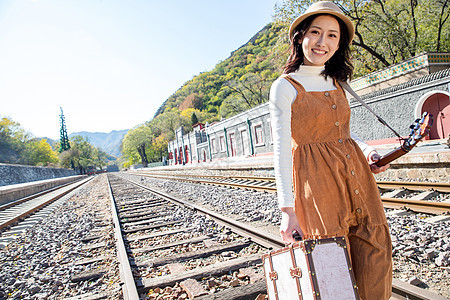 户外旅途青年女人在铁轨上行走图片