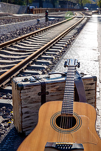 铁轨旁边的吉他和旅行箱图片