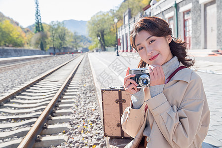 旅行的青年女人拿着照相机图片