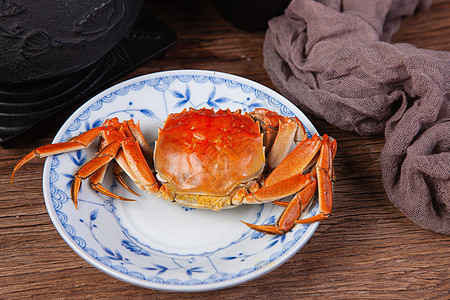一只蒸好的螃蟹放在盘子里图片