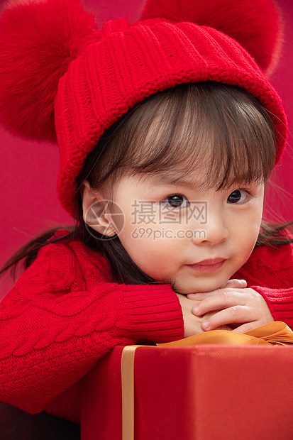 东方传统节日庆祝幸福的小女孩趴在礼物包装盒上图片