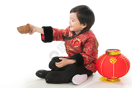 传统节日盘腿坐着东亚小男孩过年穿新衣服盘腿坐地上图片