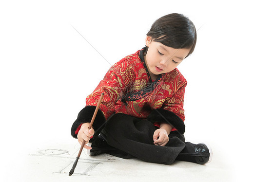 写影棚拍摄毛笔可爱的小男孩坐在地上画画图片