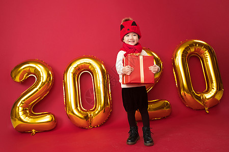 拿着数字的女孩包装盒彩色图片影棚拍摄可爱的小男孩拿着新年礼物背景