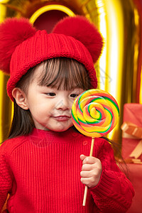 户内文化欢乐可爱的小女孩拿着棒棒糖图片