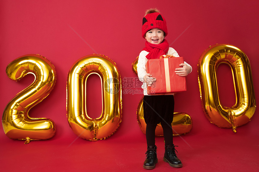 礼品盒摄影拜年可爱的小男孩拿着新年礼物图片