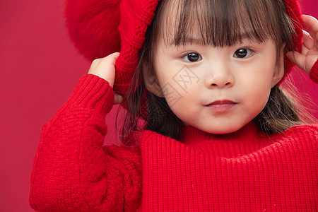 注视镜头好奇心拜年穿红衣戴红帽的可爱小女孩图片