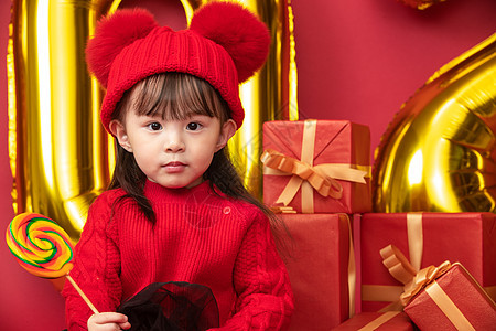 春节传统庆典红色可爱的小女孩拿着棒棒糖图片