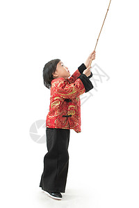 全身像人文化过新年的小男孩拿着竹竿玩耍图片