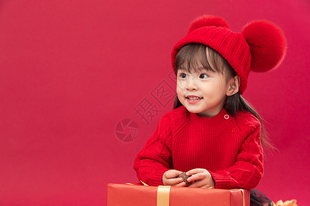 东方人不看镜头拜年可爱的小女孩趴在新年礼物上图片