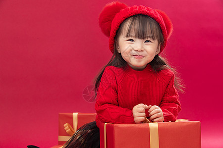 迎接水平构图幸福的小女孩趴在礼物包装盒上图片