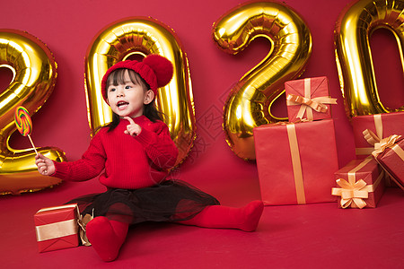 礼物红色背景活力可爱的小女孩拿着棒棒糖图片
