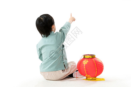 春节服装可爱的小男孩坐在地上玩耍背景