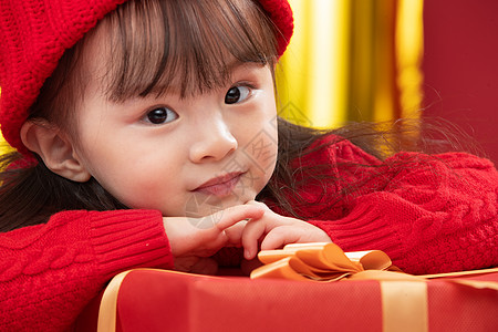 兴奋节日影棚拍摄幸福的小女孩趴在礼物包装盒上图片