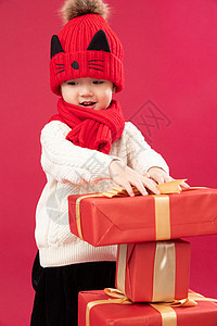 垂直构图放松围巾可爱的小男孩拿新年礼物图片
