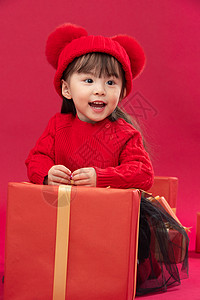 玩耍节日吉祥幸福的小女孩趴在礼物包装盒上图片