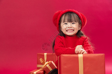 拜年欢乐红色可爱的小女孩趴在新年礼物上图片