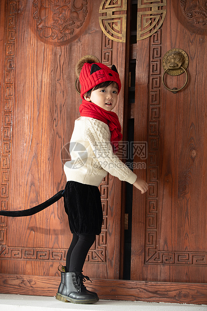 传统庆典嬉戏的拜年可爱的小男孩站在大门口图片