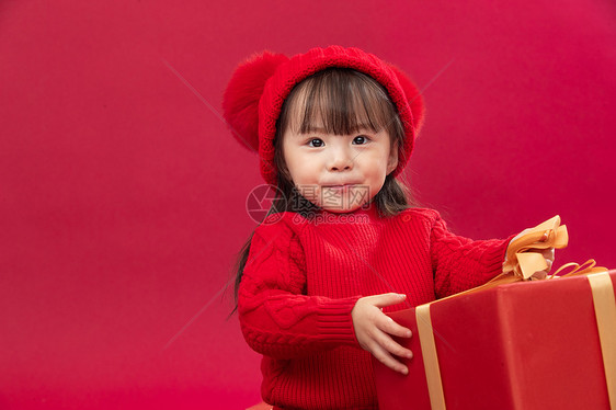 玩耍吉祥可爱的小女孩拿新年礼物上图片