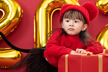传统庆典亚洲气氛可爱的小女孩趴在新年礼物上图片