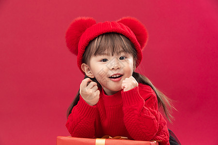 快乐无忧无虑彩色图片可爱的小女孩趴在新年礼物上图片