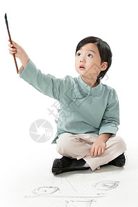 毛笔元素放松嬉戏的传统文化可爱的小男孩坐在地上用毛笔写字背景