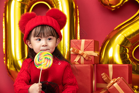 2岁到3岁过年欢乐过新年的小女孩吃棒棒糖图片