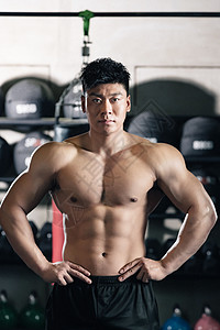 年轻男子健身年轻男子在健身房展示肌肉背景
