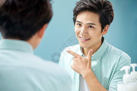 学生清新英俊自信的年轻男人对着镜子做手势图片