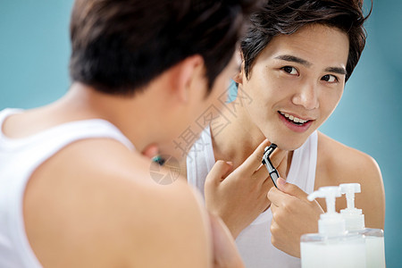 青年男人对着镜子刮胡子图片