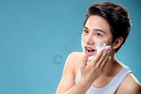 身体保健涂抹剃须膏的年轻男人图片