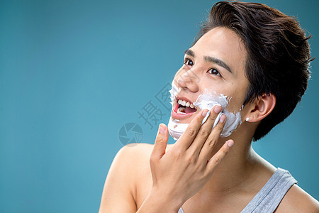 健康生活方式涂抹剃须膏的年轻男人图片