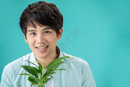 青年人自然亚洲人拿着绿色植物的青年男人图片